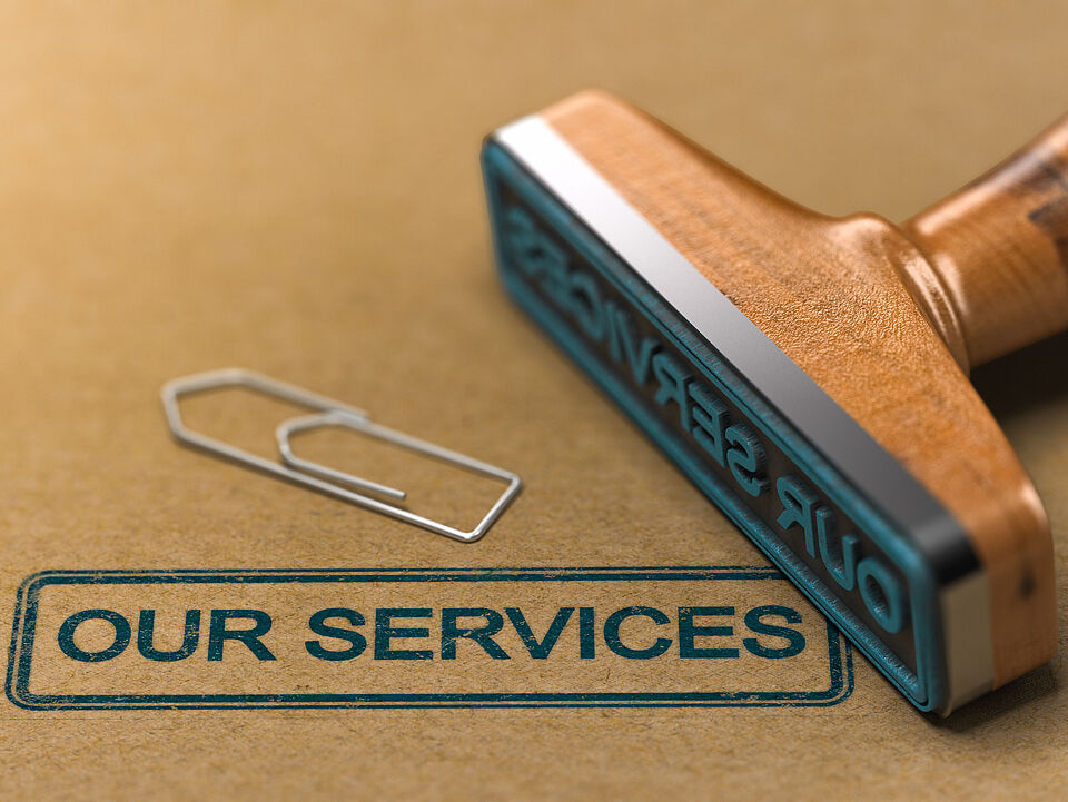 a paper clip and a stamp with which "our services" was stamped on a brown background