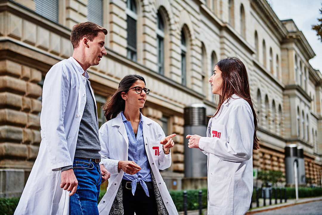Three scientists having a conversation on campus