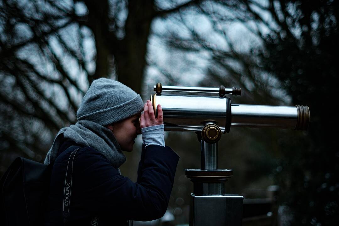 A person looking through a telescope