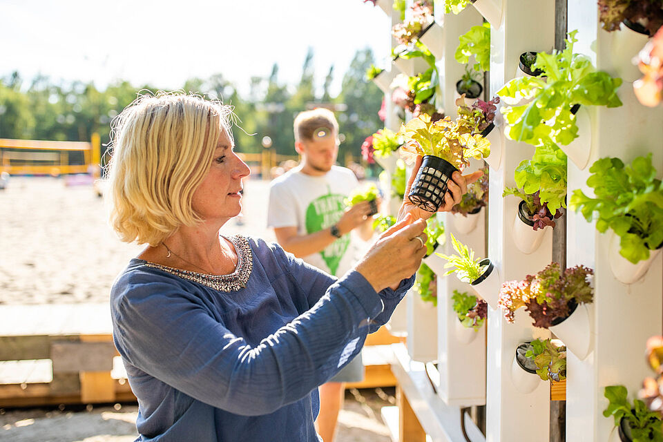 Scientist looks at plants on the vertical farm called "Shower Tower"