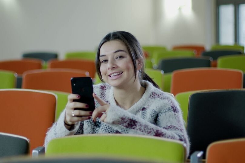 Studierende im Hörsaal mit Smartphone