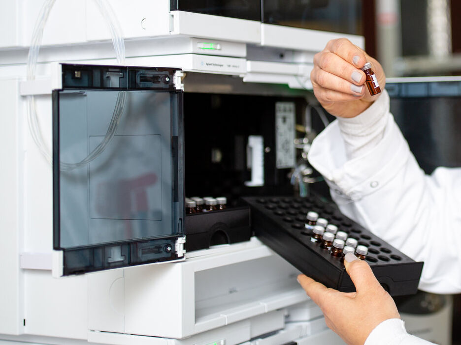 Eine Wissenschaftlerin platziert von Proben in der Hochleistungsflüssigkeitschromatographie