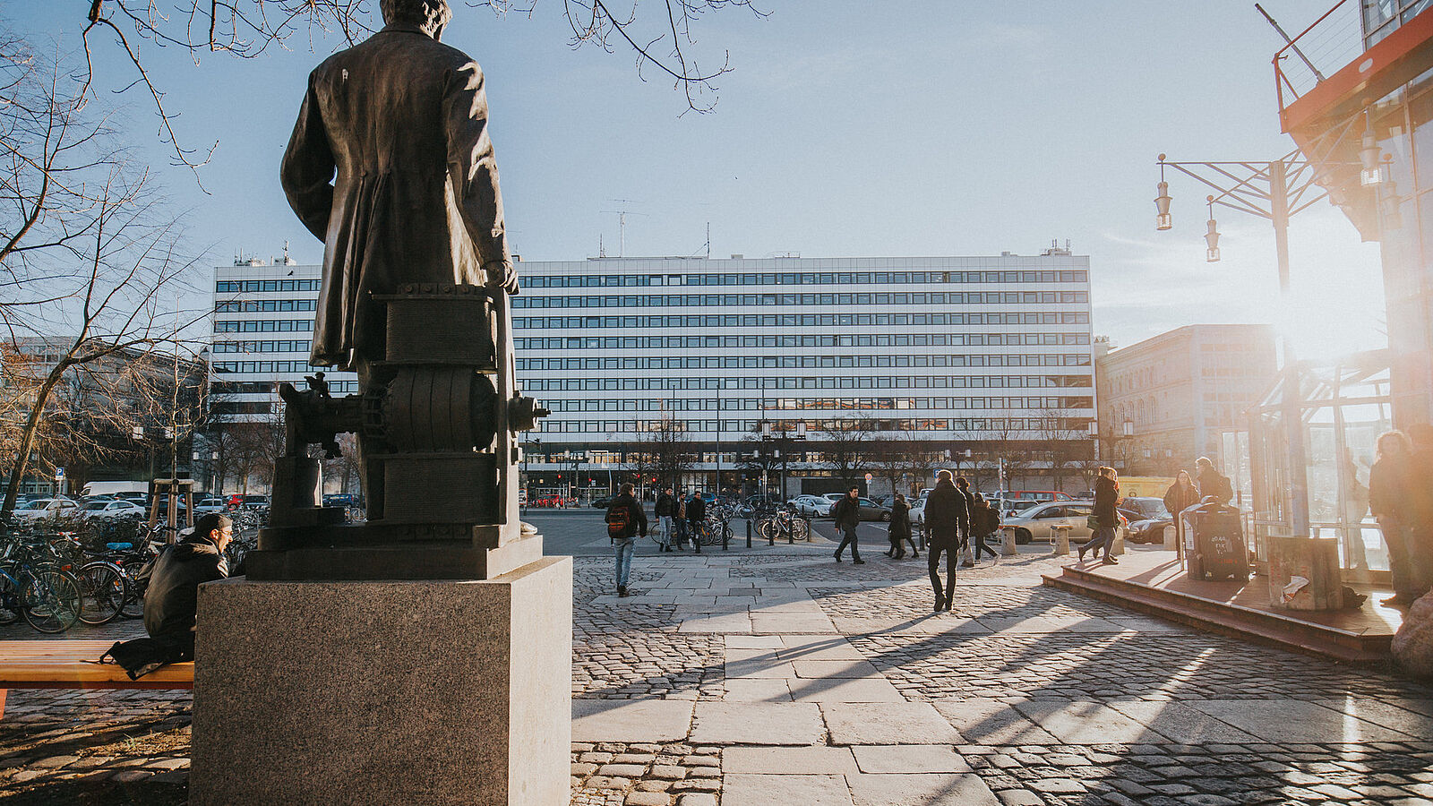 Rückseite der Statue von Werner von Siemens am Mathematikgebäude mit Blick über die Straße des 17. Juni auf das Hauptgebäude im Sonnenschein