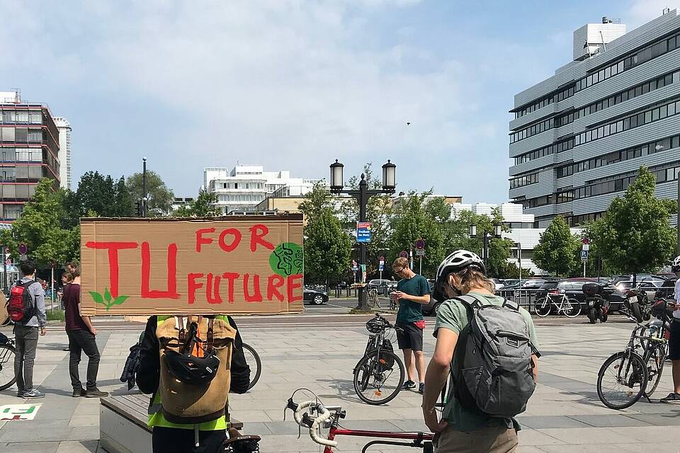 Mehrere Personen mit dem Fahrrad und Demoschild "TU for Future"