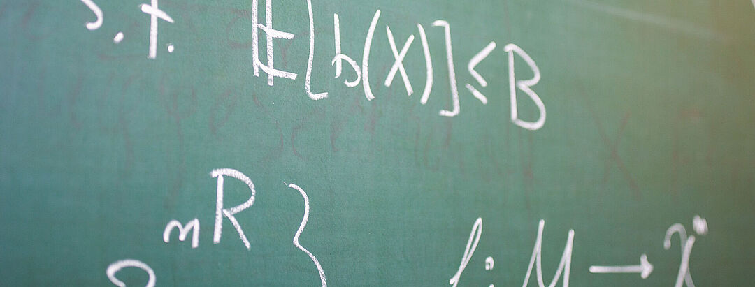 Formulas written in chalk on a green blackboard
