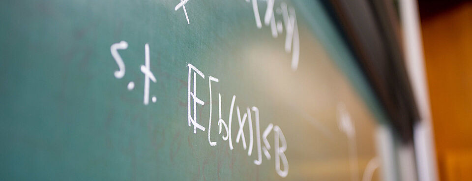 Formulas written in chalk on a green blackboard