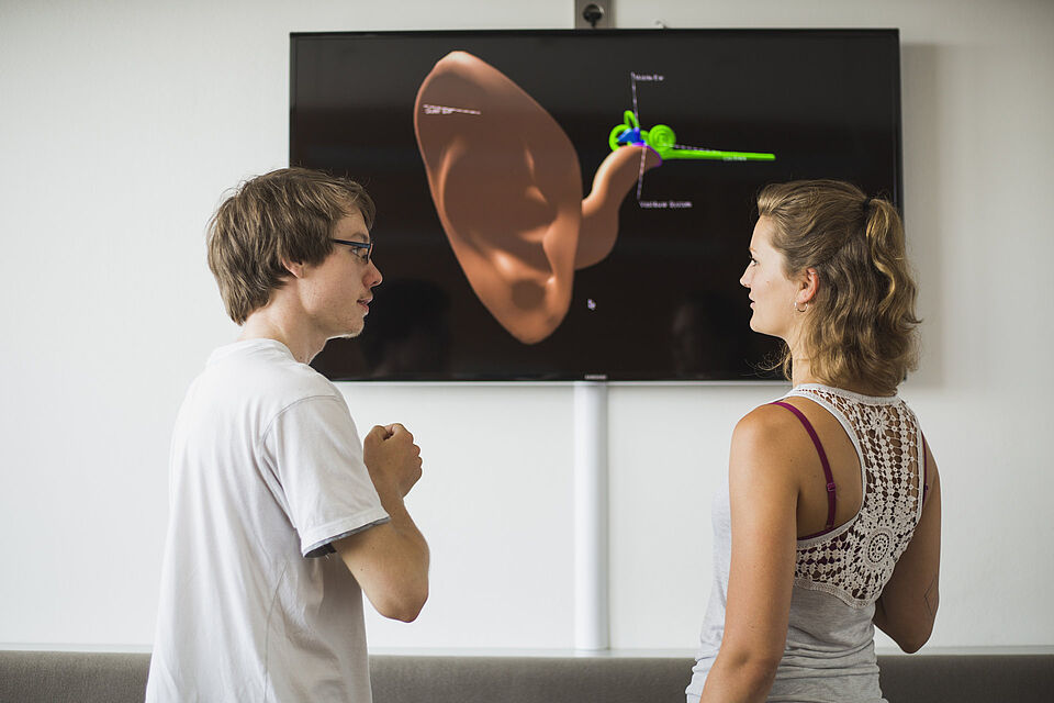 Studierende des Studiengangs Medieninformatik vor dem Modell eines menschliches Ohres