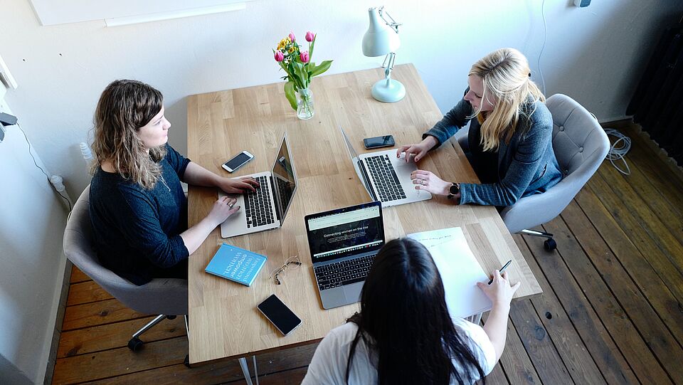Three women  in a discussion in an office