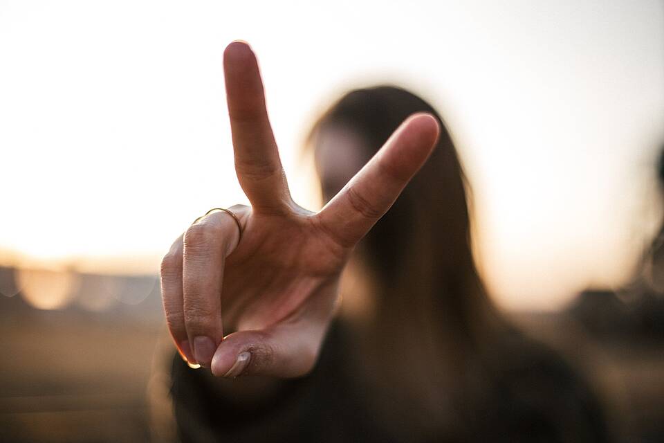 Symboldbild: Frau streckt zwei Finger in die Kamera