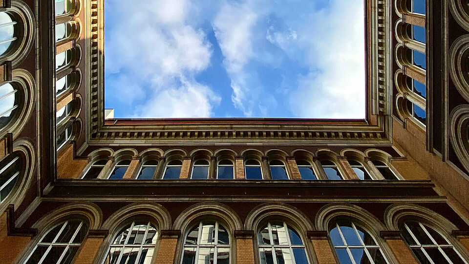View of the sky from the patio of the main building, the facade of the building frames the sky