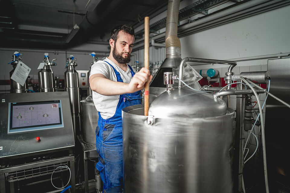 Research brewery at the TU Berlin: a trainee operates one of the large boilers in the laboratory