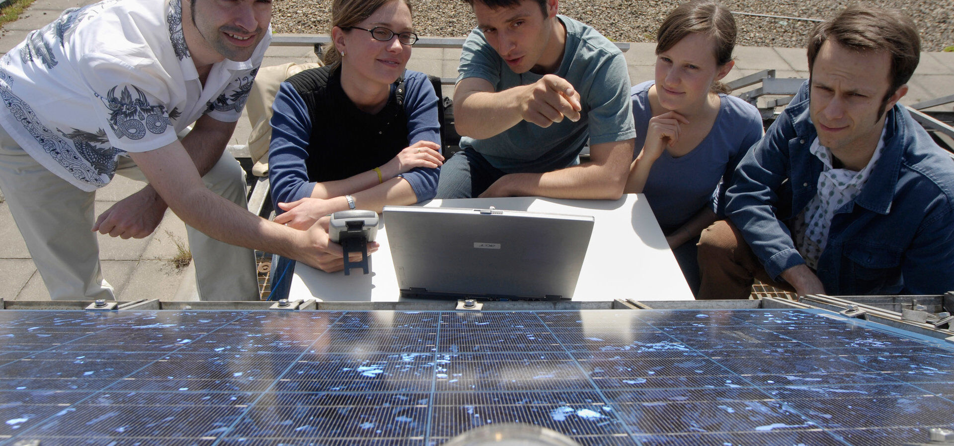 Auf dem Dach des Elektrotechnikneubau der Technischen Universität Berlin. Ein Wissenschaftler erläutert Besuchern wie die Unterschiede zwischen verschiedenen Solarmodulen ermittelt werden, sie blicken auf ein Panel und Messgeräte