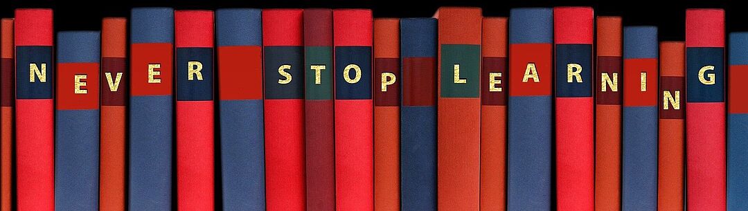 Bücherrücken mit Beschriftung "Never Stop Learning"