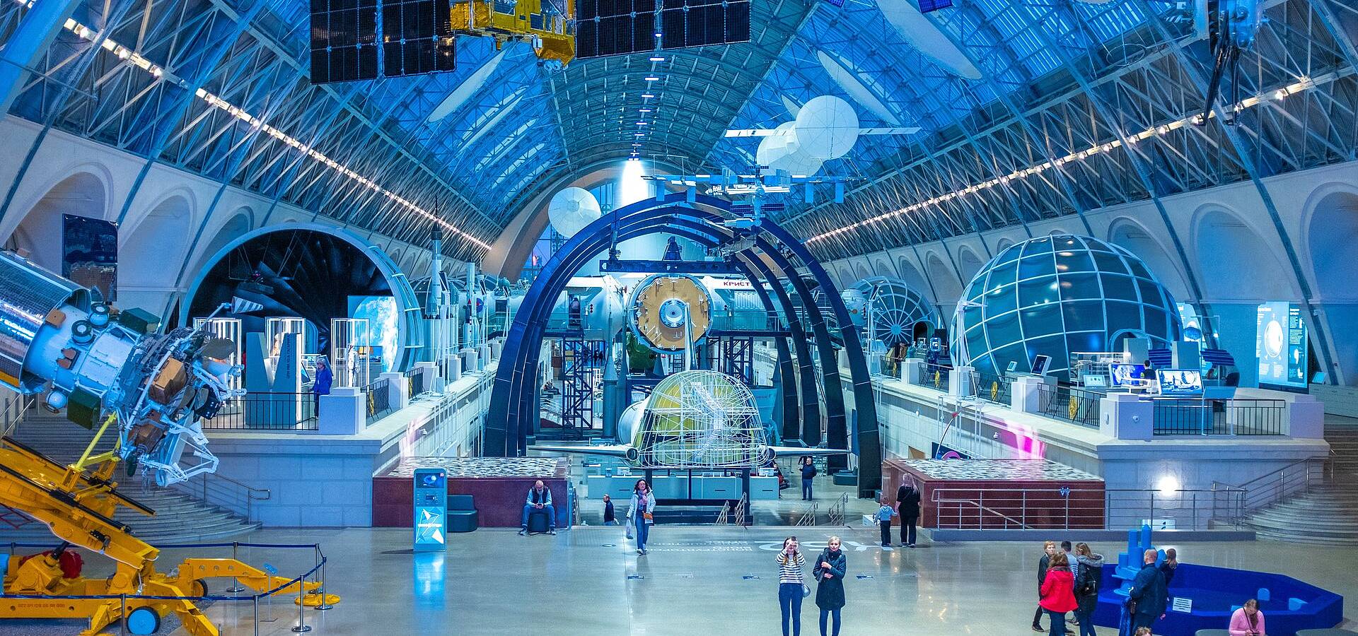 Blick in die riesige Halle eines Science Centers mit Besucher*innen darin