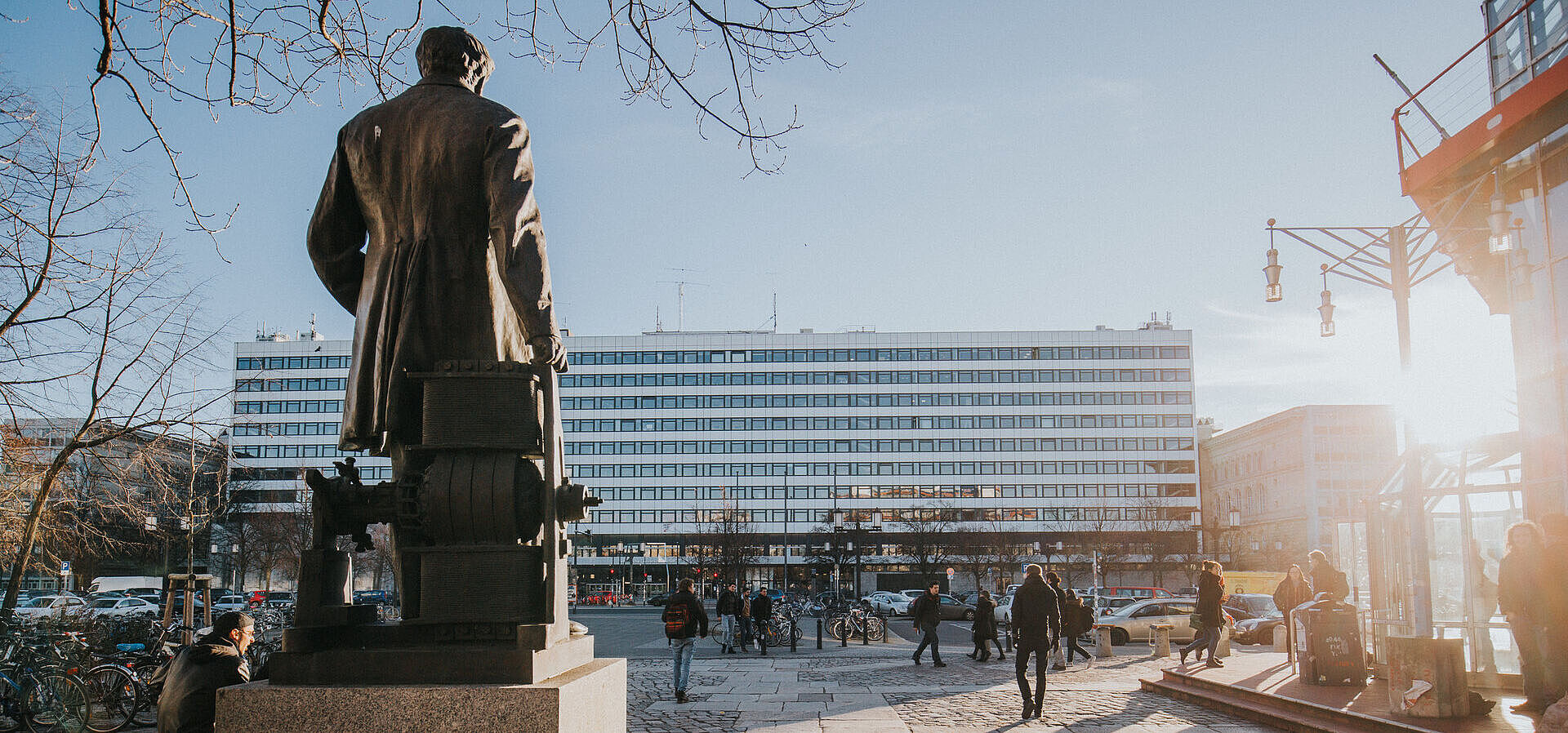 Rückseite der Statue von Werner von Siemens am Mathematikgebäude mit Blick über die Straße des 17. Juni auf das Hauptgebäude im Sonnenschein