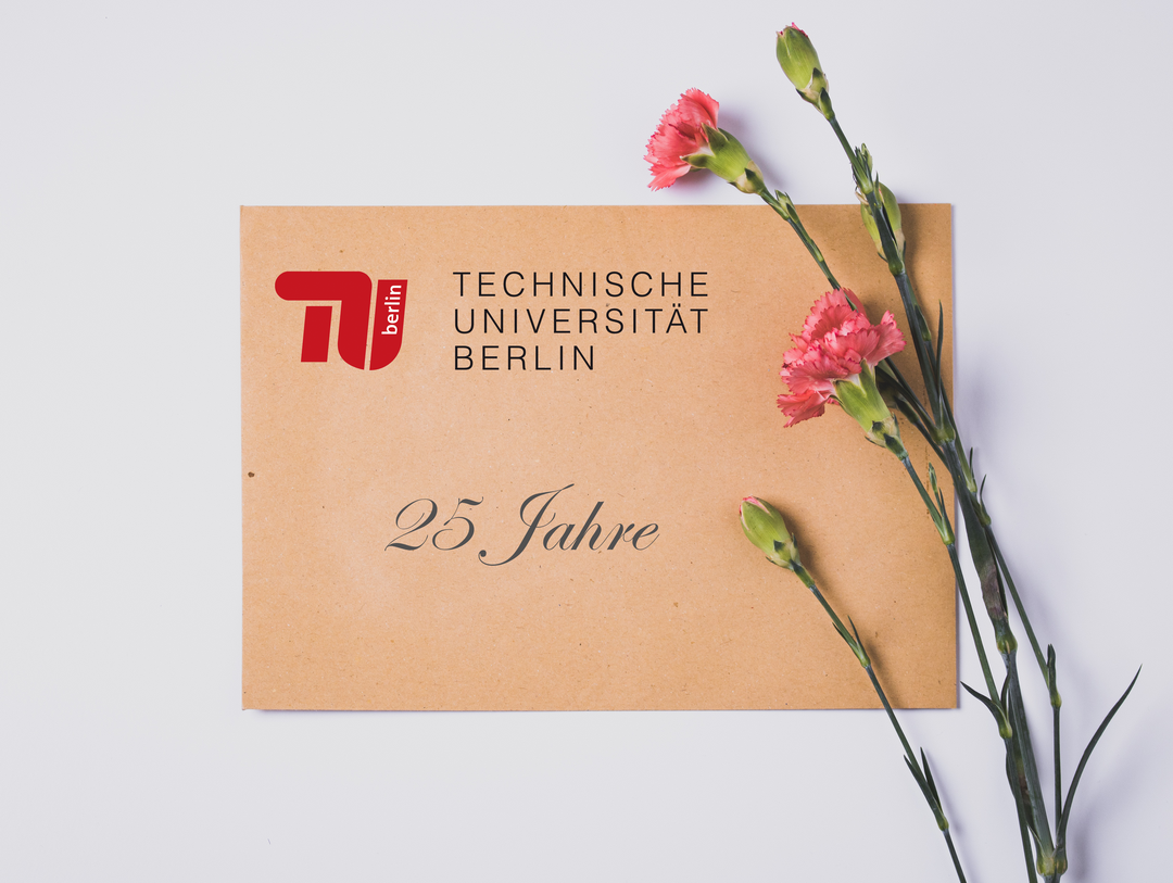 Briefumschlag mit Aufschrift 25 Jahre TU Berlin sowie danebenliegender Nelke