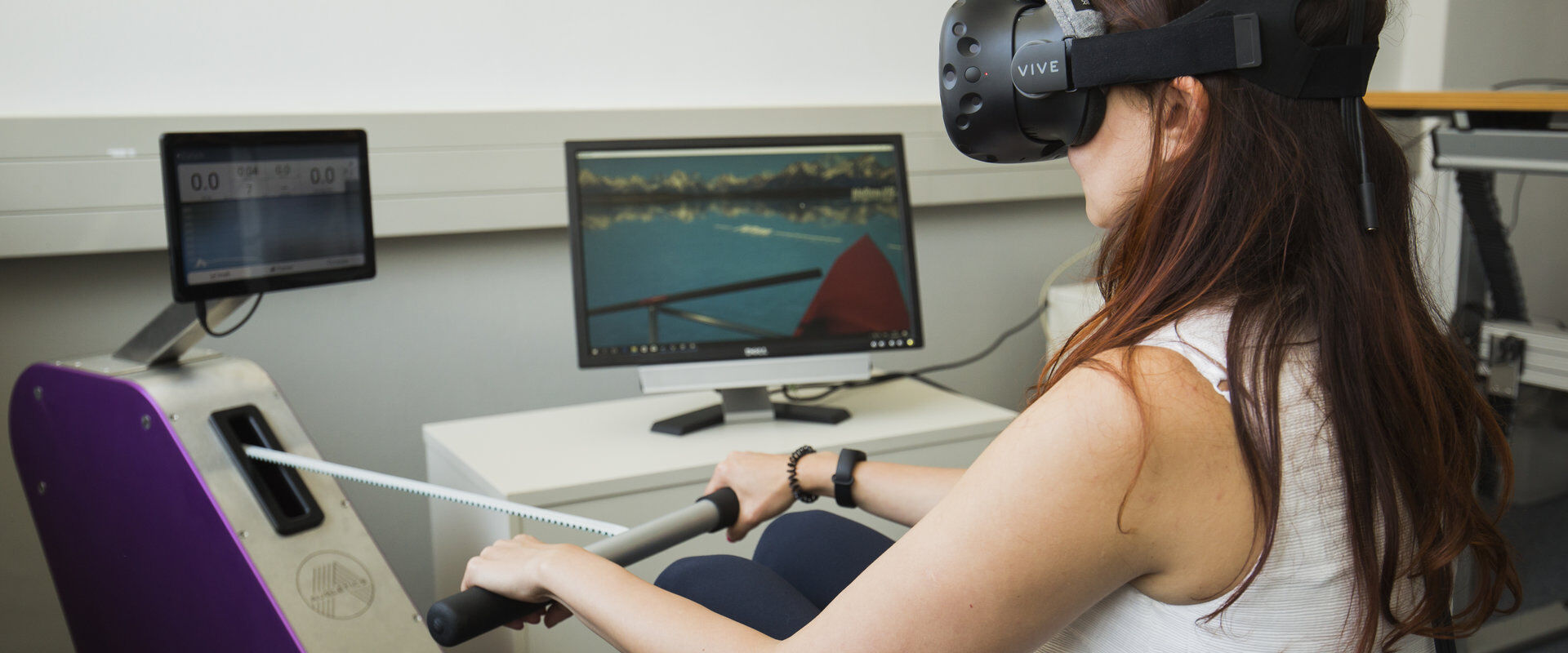 Studierende des Studiengangs Medieninformatik mit einer VR-Brille auf einem Rudergerät