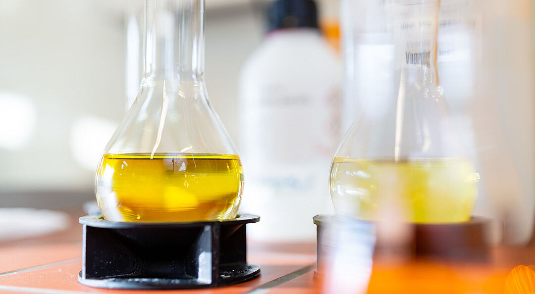 Two Erlenmeyer flasks filled with a yellow liquid